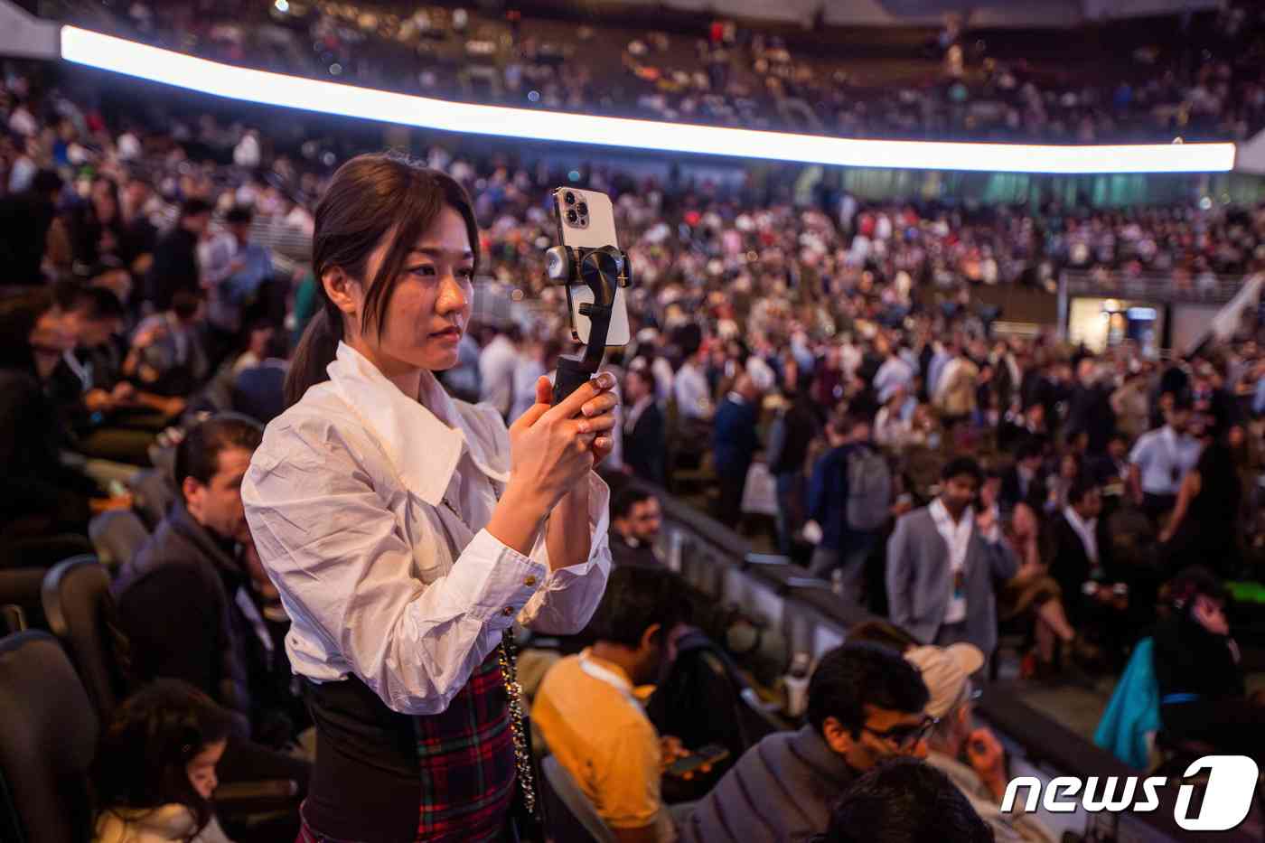 미국 네브라스카주 오마하에서 열린 버크셔 해서웨이의 연례 주주총회 현장에서 한 참석자가 스마트폰으로 사진을 찍고 있다. © 로이터=뉴스1 © News1 신기림 기자