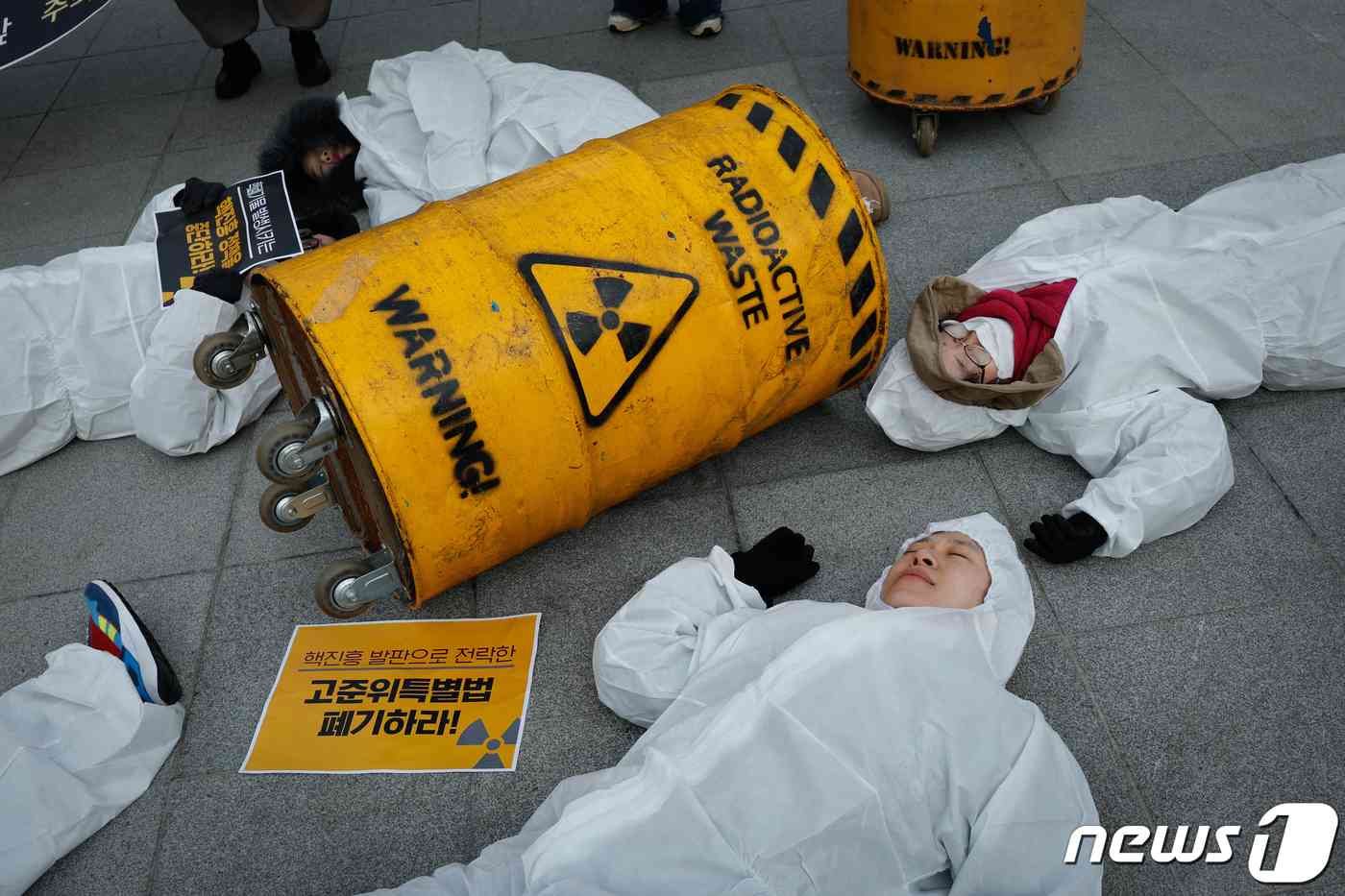 탈핵시민행동, 종교환경회의 회원들이 29일 오전 서울 종로구 광화문 광장에서 '고준위방사성폐기물특별법' 폐기를 촉구하며 쌓여있는 핵폐기물 위에 놓여있는 사람들을 상징하는 퍼포먼스를 하고 있다. 2023.11.29/뉴스1 © News1 안은나 기자