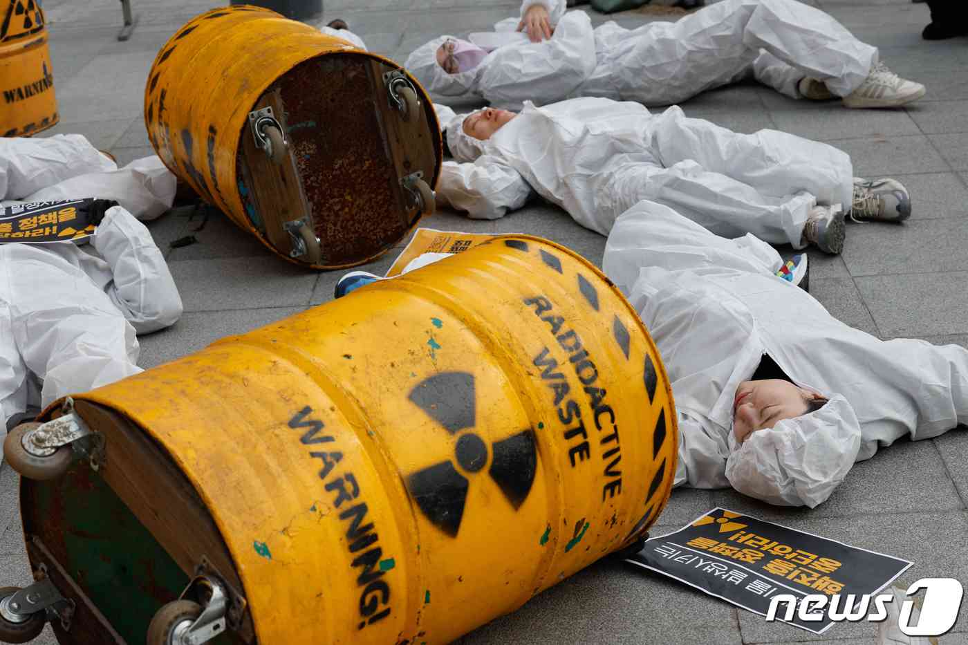 탈핵시민행동, 종교환경회의 회원들이 29일 오전 서울 종로구 광화문 광장에서 '고준위방사성폐기물특별법' 폐기를 촉구하며 쌓여있는 핵폐기물 위에 놓여있는 사람들을 상징하는 퍼포먼스를 하고 있다. 2023.11.29/뉴스1 © News1 안은나 기자