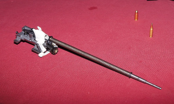 노리쇠뭉치. 용수철이 감겨있는 부분은 가스피스톤에 의해 뒤로 밀리는 작동 밀대(오퍼레이팅 로드)이다. 흰색 부품이 탄피를 위로 보내는 엘리베이터(리프터라고도 한다). <출처 : 홍희범>