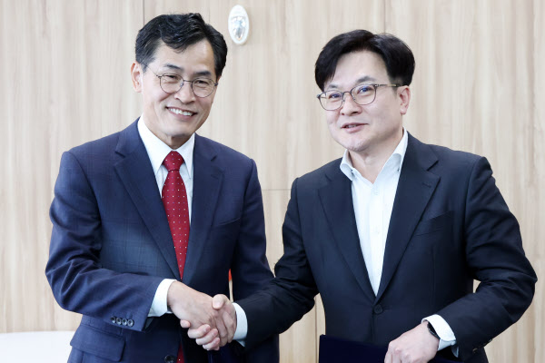 [땅집고] 이기재 양천구청장(왼쪽)과 김병수 김포시장이 21일 오전 서울 중구 서울시청에서 '서울 지하철 2호선 신정지선 김포 연장 협약서'를 공개한 뒤 악수를 나누고 있다. /뉴스1