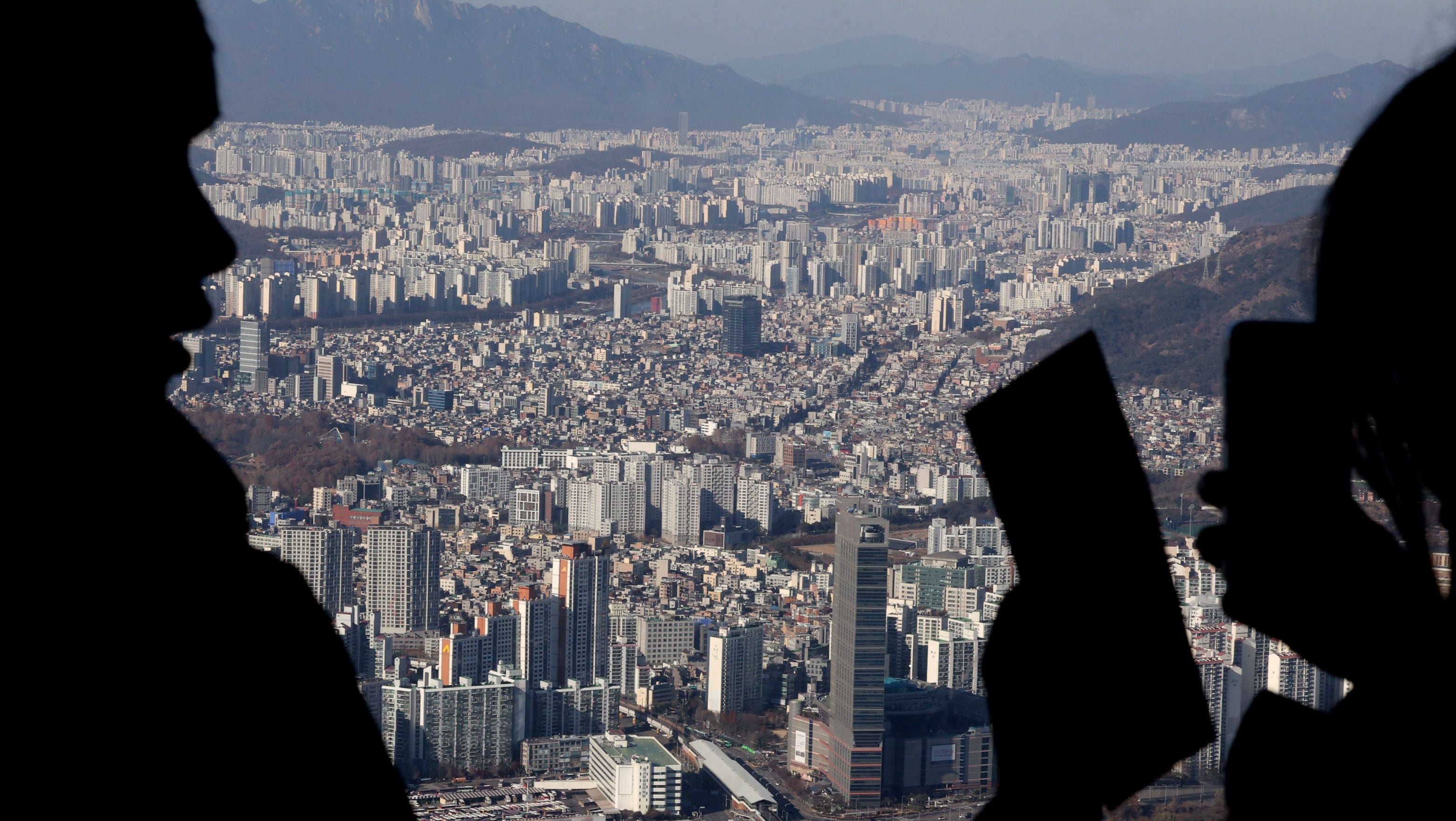 서울 송파구 롯데월드타워 전망대를 찾은 관람객이 아파트 단지를 바라보고 있다. /뉴스1