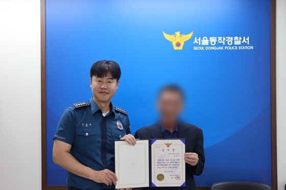 김승혁 서울 동작경찰서장이 말기 암환자를 도운 택시 기사에게 감사장을 수여하고 있다. (서울 동작경찰서 제공)