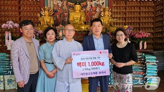 금산 부석사 장곡 스님(가운데)이 부처님오신날을 맞아 신도들이 십시일반 모아 준비한 백미를 심완보 부군수(오른쪽 두번째)에게 전달한 후 기념사진을 찍고 있다.(금산군 제공)/ 뉴스1
