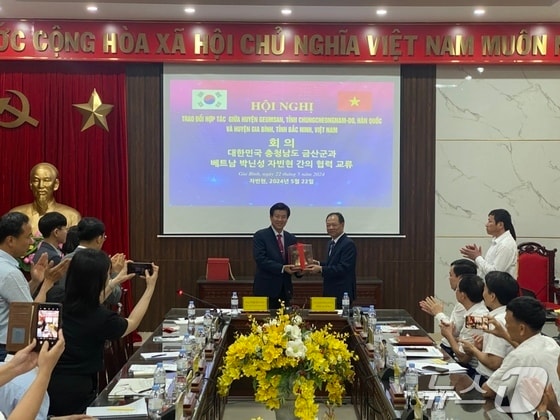 박범인 금산군수(왼쪽)가 자빈현을 방문해 당딘맛 인민위원회 위원장(오른쪽)과 기념사진을 찍고 있다.(금산군 제공) / 뉴스1