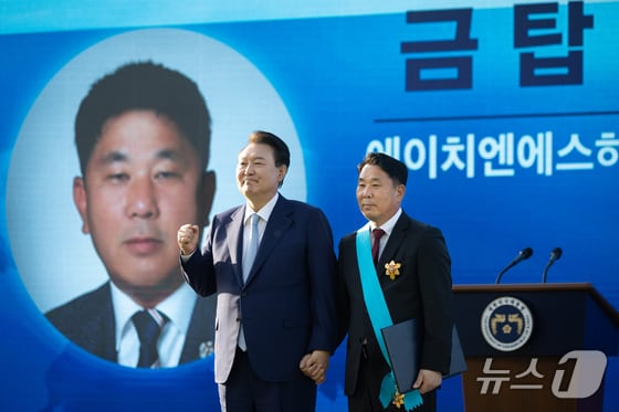 윤석열 대통령이 23일 용산 대통령실 청사 잔디마당에서 열린 2024 대한민국 중소기업인대회에서 김정희 에이치엔에스하이텍 대표이사에게 금탑산업훈장을 수여한 후 기념촬영을 하고 있다. (대통령실 제공) 2024.5.23/뉴스1 © News1 오대일 기자