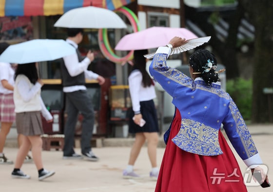 서울 종로구 국립민속박물관에서 외국인 관광객이 부채로 비를 피하고 있다. 2024.5.15/뉴스1 © News1 이재명 기자