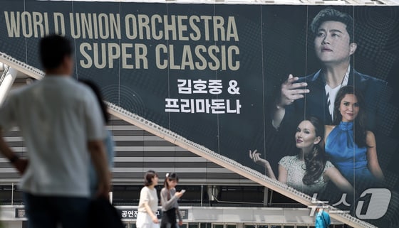 22일 오후 서울 송파구 올림픽공원 KSPO돔(체조경기장)에 설치된 '월드 유니온 오케스트라 슈퍼 클래식 : 김호중 & 프리마돈나’ 현수막 앞으로 시민들이 지나가고 있다. 2024.5.22/뉴스1 © News1 박지혜 기자