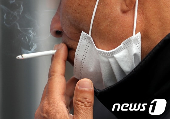 세계 금연의 날인 31일 서울역 흡연실에서 한 시민이 마스크를 내리고 담배를 피고 있다. <자료사진>2021.5.31/뉴스1 © News1 이성철 기자