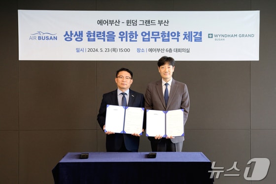  마호진 에어부산 영업본부장(왼쪽)과 박지호 윈덤그랜드부산 총지배인이 23일 부산 강서구 에어부산 사옥에서 업무협약을 맺고 기념사진을 찍고 있다.(에어부산 제공)