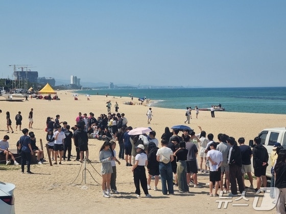 강원 강릉지역의 낮 최고기온이 33도를 웃돈 23일 강릉 견소동 커피거리 해변을 찾은 수학여행단이 양산을 쓰고 무더위를 피하고 있다. 2024.5.23/뉴스1