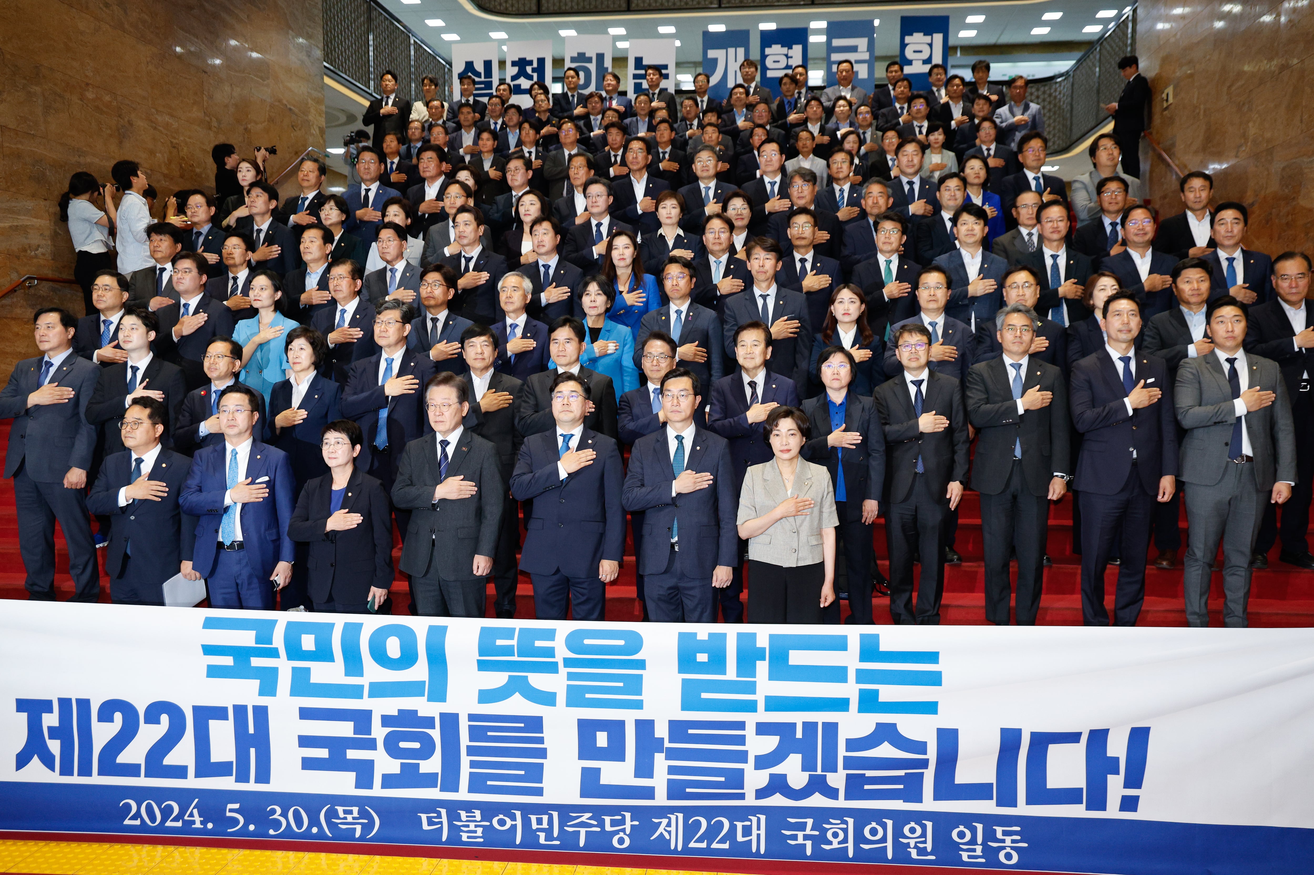 이재명 더불어민주당 대표와 박찬대 원내대표를 비롯한 의원들이 제22대 국회 개원 첫날인 30일 오후 서울 여의도 국회 로텐더홀에서 열린 첫 의원총회에 참석해 국민의례를 하고 있다. 2024.5.30/뉴스1 ⓒ News1 안은나 기자