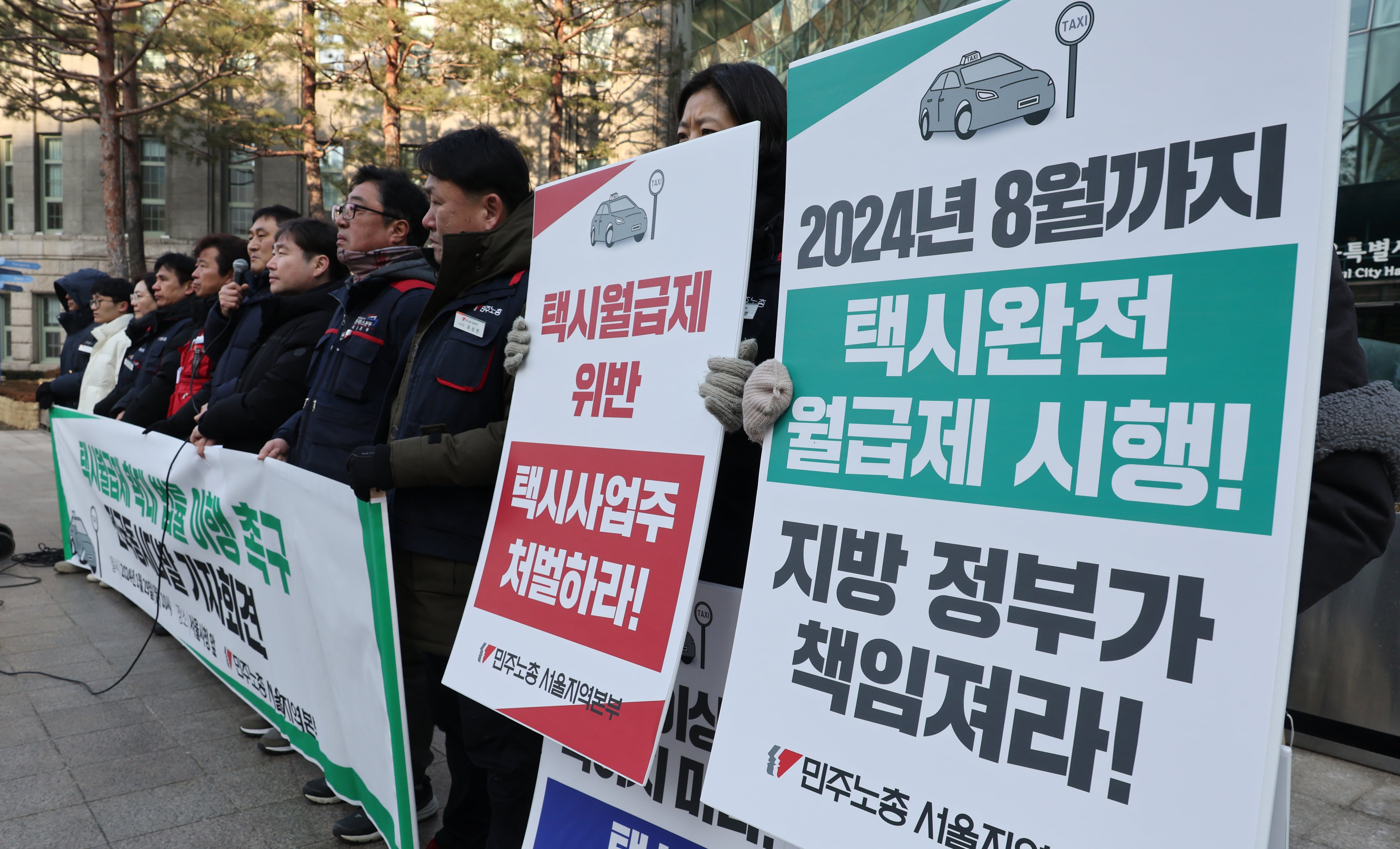 지난 1월 29일 서울 시청 앞에서 열린 민주노총 택시월급제 시행 촉구 기자회견에서 참석자들이 '택시발전법 11조2항에 따른 택시월급제 시행'을 주장하고 있다. /연합뉴스