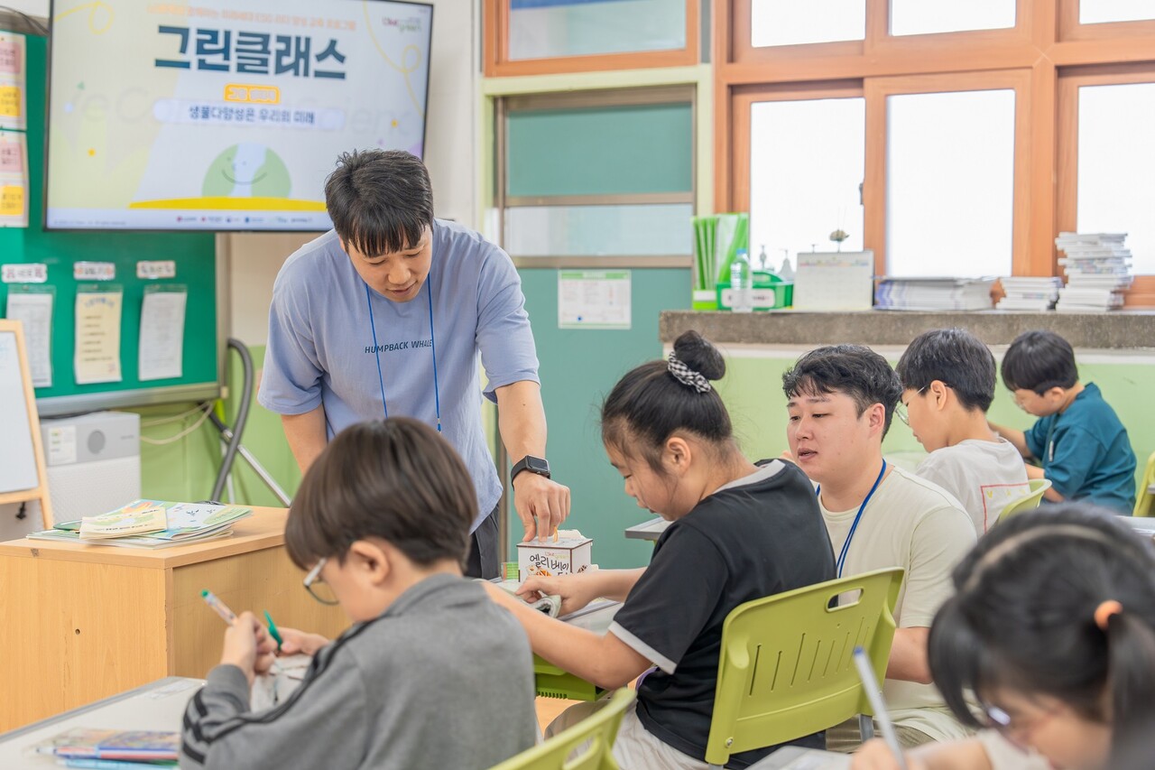 일일 선생님이 된 LG화학 임직원이 아이들과 멸종위기생물 무드등 만들기 체험을 하고 있다. / LG화학