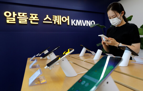 한 시민이 2022년 6월 21일 서울 시내 알뜰폰 스퀘어 매장에서 휴대폰을 살피고 있다. / 뉴스1