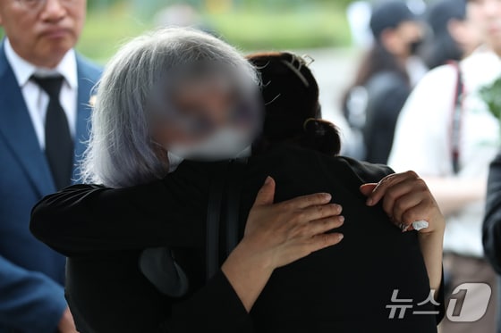 19일 오후 서울 용산구 용산역광장에 마련된 지난달 육군 신병교육대에서 군기훈련(얼차려)을 받다 숨진 훈련병의 시민 추모 분향소에서 고인의 어머니가 추모객과 포옹하고 있다. 2024.6.19/뉴스1 © News1 이승배 기자