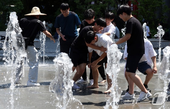서울 한낮 기온이 29도까지 오르는 등 초여름 날씨를 보인 4일 서울 광화문광장 분수대에서 학생들이 더위를 식히고 있다. 2024.6.4/뉴스1 © News1 김명섭 기자