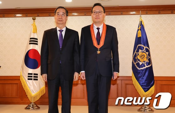 한덕수 국무총리가 지난 2월 15일 서울 종로구 정부서울청사에서 열린 규제개혁유공 포상 수여식에서 최현석 고용노동부 실장에게 홍조근정훈장을 전수한 뒤 기념촬영을 하는 모습. 2024.2.15/뉴스1 © News1 허경 기자