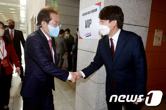 홍준표 국민의힘 대선 경선 후보(왼쪽)가 5일 오후 서울 용산구 백범김구기념관에서 열린 제2차 전당대회에 참석하기 전 이준석 국민의힘 대표와 악수를 나누고 있다. 2021.11.5/뉴스1 © News1 오대일 기자
