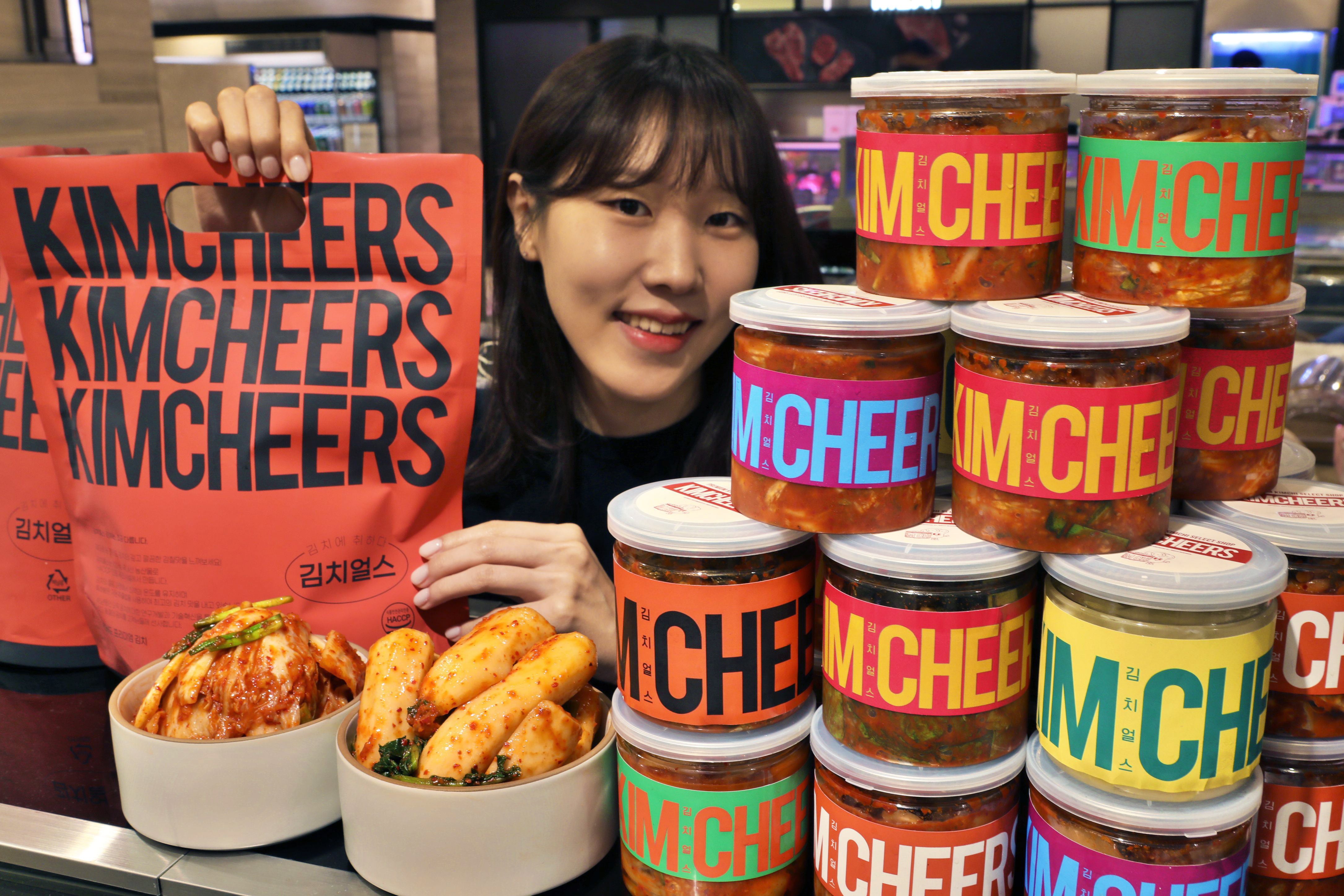 롯데백화점이 16일 본점 지하 1층 식품관에서 진행 중인 '김치얼스' 팝업 매장에서 제품을 들고 있는 모습. /롯데백화점 제공