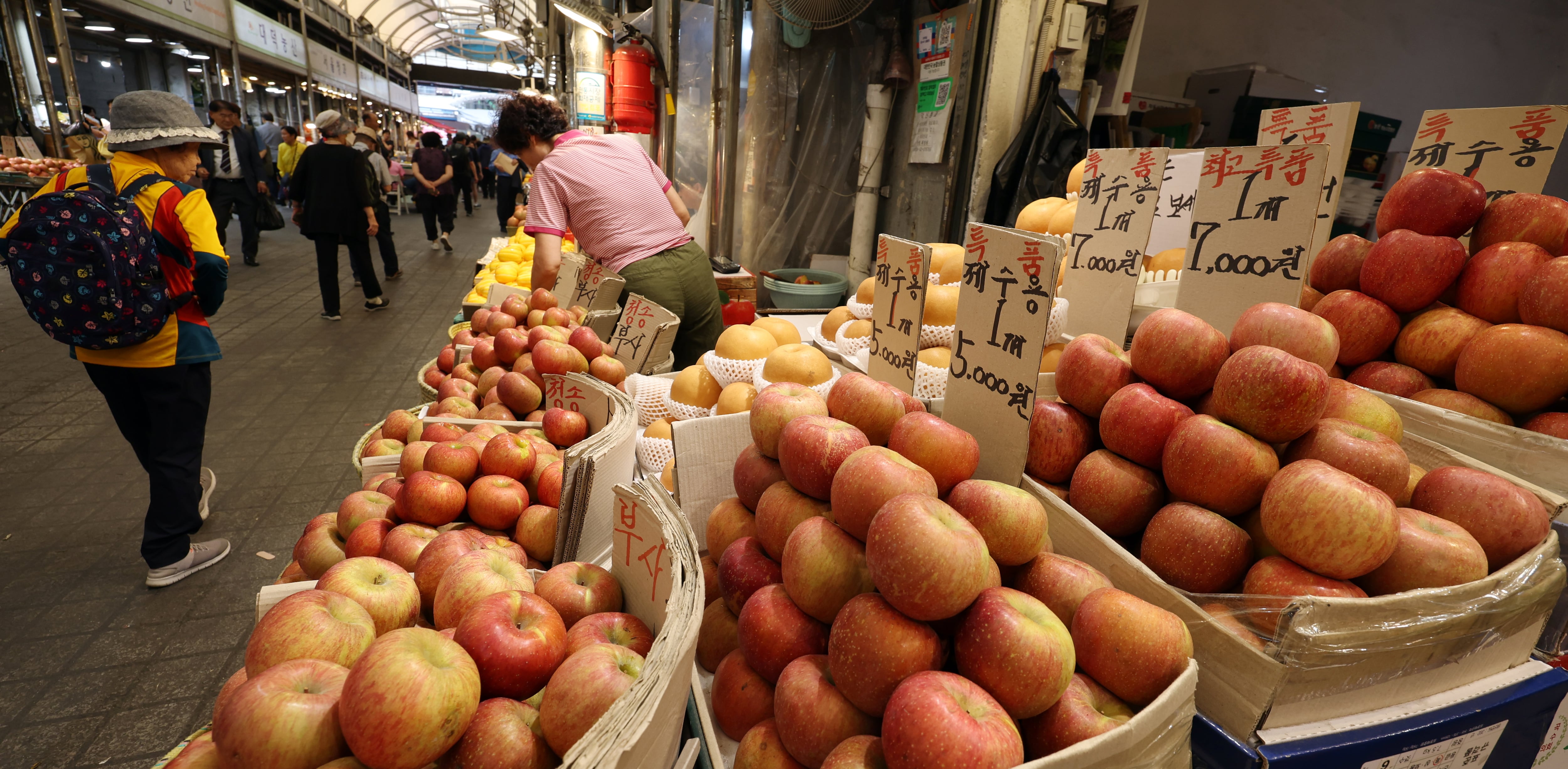 지난 7일 서울 동대문구 한 재래시장에서 시민들이 과일을 살펴보고 있다. /뉴스1