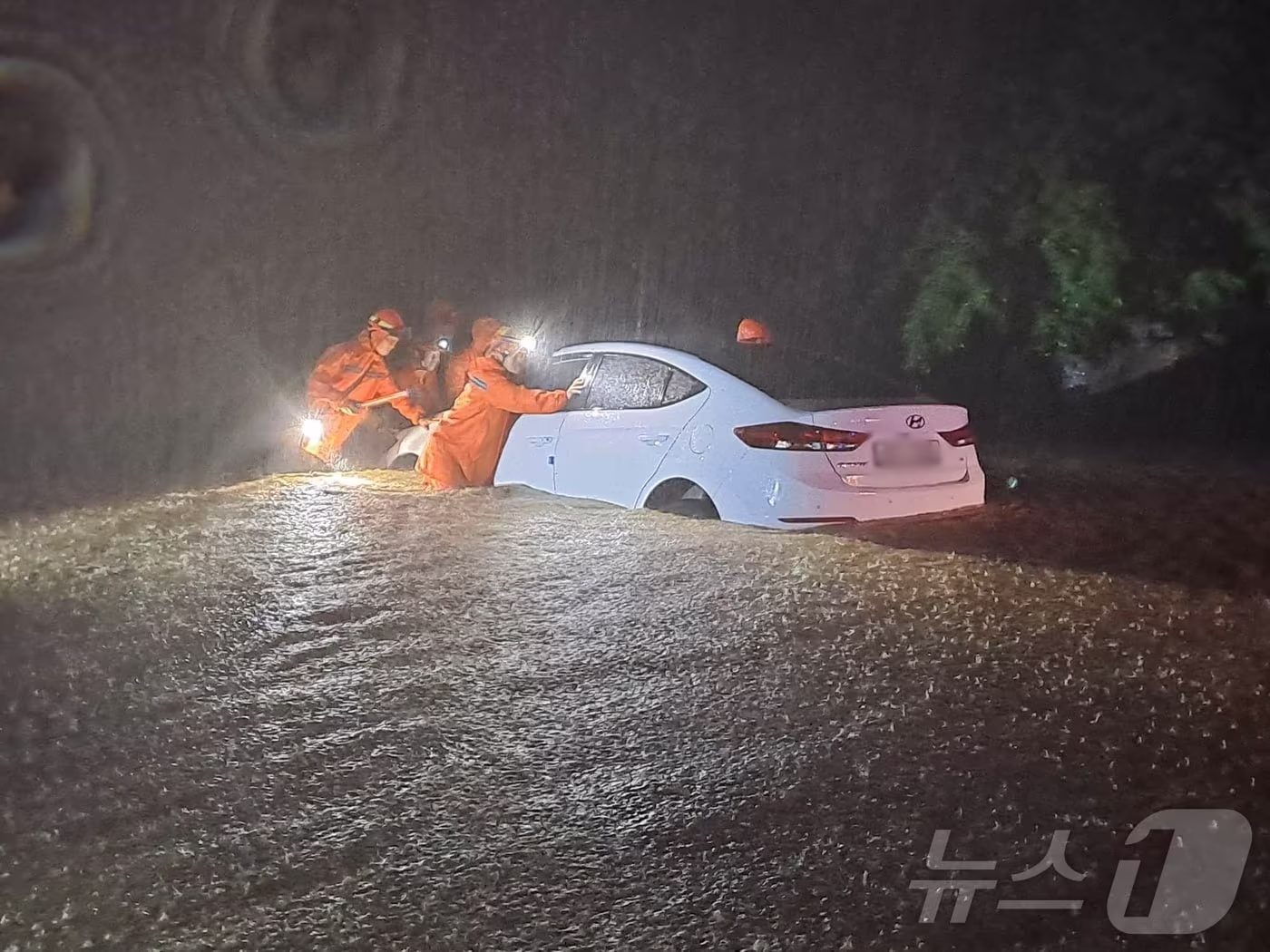 23일 강원 내륙을 중심으로 호우특보가 내려진 가운데 밤사이 강원 철원군 갈말읍 내대리의 한 도로에 차량이 침수돼 소방대원들이 차량을 이동시키고 있다. (강원도소방본부 제공) 2024.7.23/뉴스1 ⓒ News1 윤왕근 기자