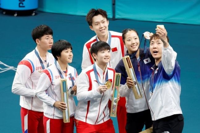 임종훈과 신유빈이 30일(현지시각) 프랑스 파리 사우스 파리 아레나에서 열린 2024 파리 올림픽 탁구 혼합복식 시상식에서 동메달을 목에 걸고 금메달을 획득한 중국의 왕추친-쑨잉사, 은메달을 획득한 북한 리정식-김금용과 삼성 Z 플립6로 기념촬영을 하고 있다. 2024.07.30. ⓒ뉴시스