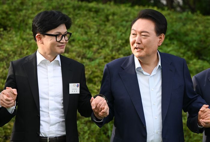 윤석열 대통령이 7월 24일 서울 용산 대통령실 청사에서 국민의힘 신임 당 지도부 만찬에 앞서 한동훈 신임 당대표와 기념촬영을 위해 손을 잡고 있다. ⓒ뉴시스