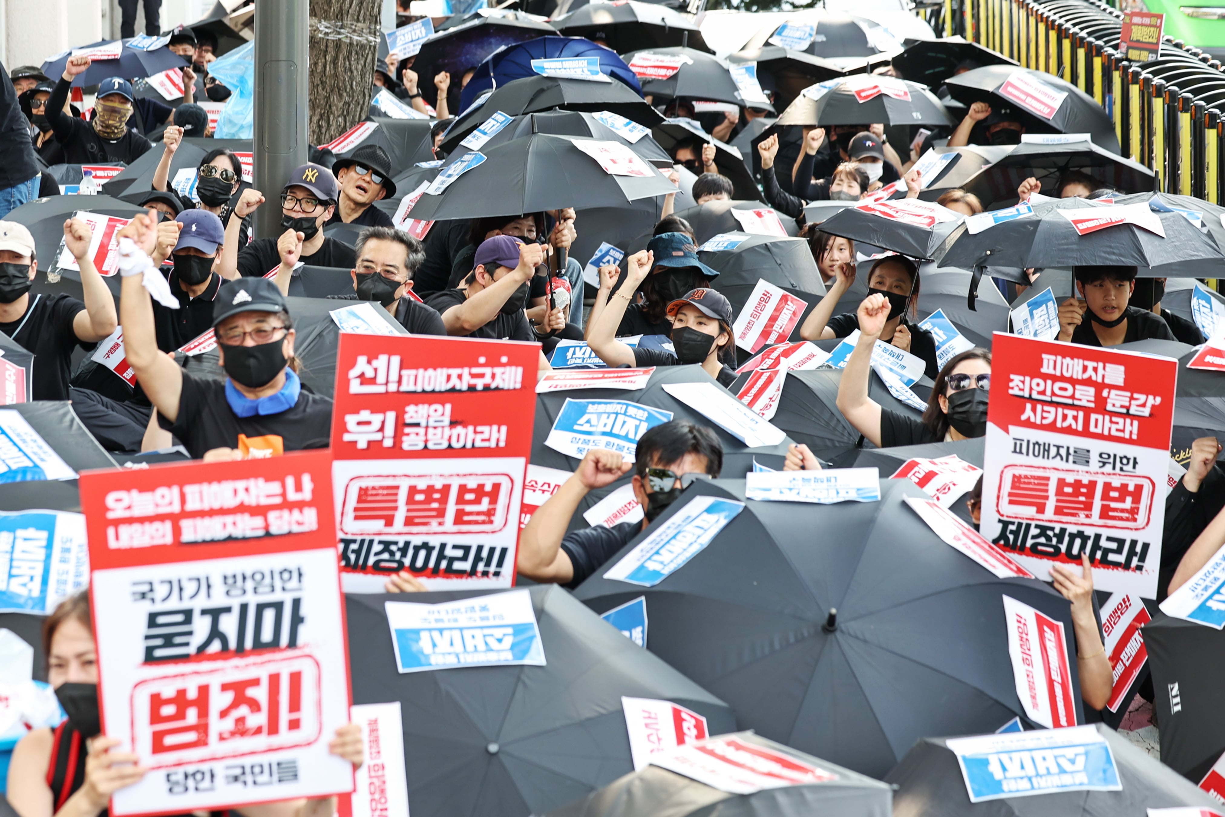 '티메프 사태' 피해자들이 18일 오후 서울 종로구 사직로 일대에서 열린 검은우산 집회에서 구호를 외치고 있다./뉴스1