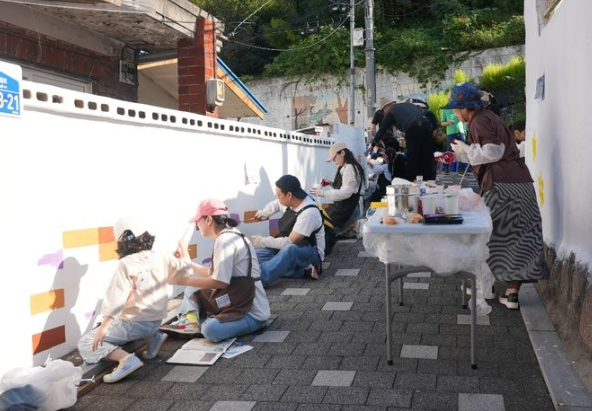 한국투자증권 임직원과 가족들로 구성된 참벗나눔 봉사단이 지난 28일 서울 은평구 녹번산골마을에서 '행복나눔 벽화그리기'를 진행했다(사진제공/한국투자증권)