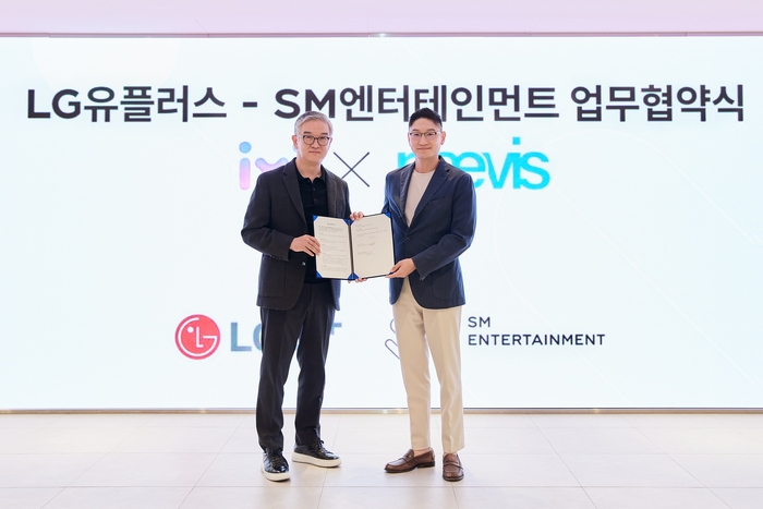 정수헌 LG유플러스 컨슈머부문장(왼쪽)과 탁영준 SM엔터테인먼트 대표가 지난달 29일 서울 성수동 SM 사옥에서 업무협약식을 진행하고 기념사진을 촬영하고 있다.