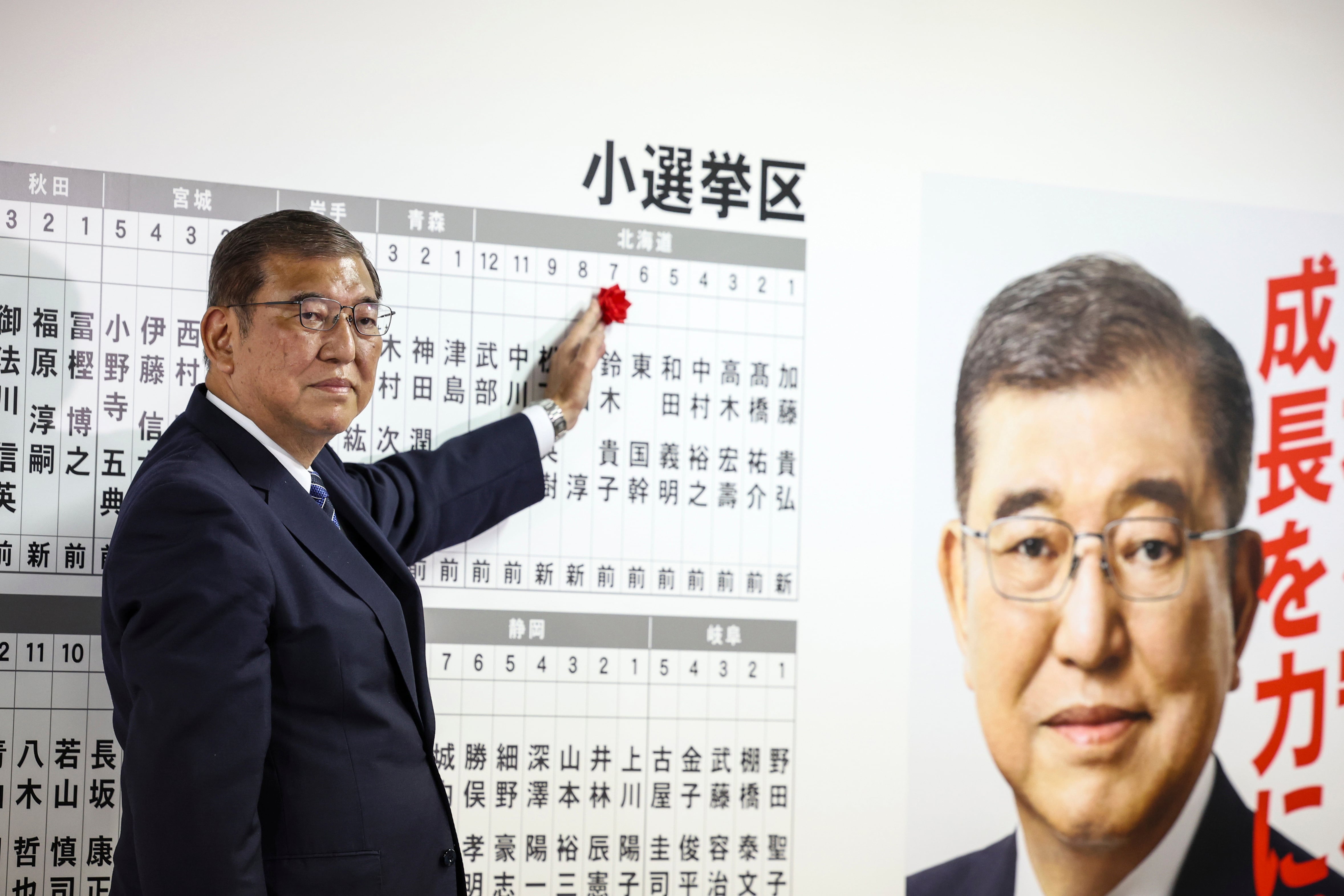 이시바 시게루 일본 총리가 27일 도쿄 자민당 본부에서 당선자 게시판에서 장미꽃을 붙이고 있다./연합뉴스
