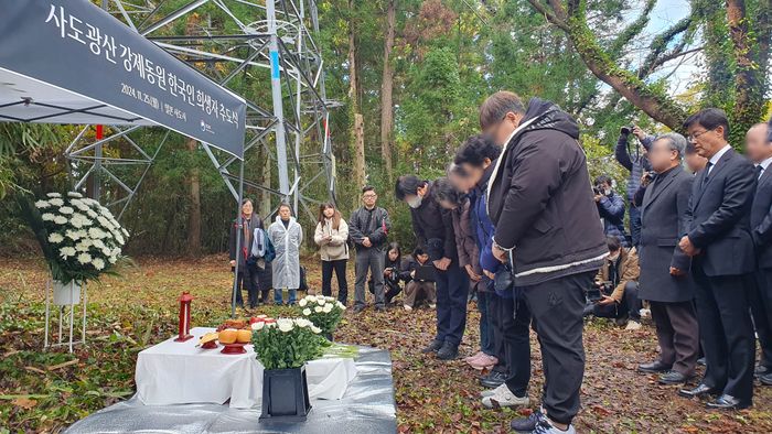 우리측 유족과 참석자들이 25일 일본 니가타현 사도광산 조선인 기숙사 터에서 열린 사도광산 강제동원 한국인 희생자 추도식에서 헌화한 뒤 묵념하고 있다. ⓒ연합뉴스