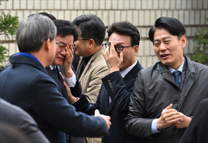 이재명 더불어민주당 대표가 위증교사 혐의 1심 무죄 선고를 받은 25일 서울 서초동 서울중앙지방법원에서 더불어민주당 의원들이 눈물을 흘리며 자축하고 있다. ⓒ사진공동취재단