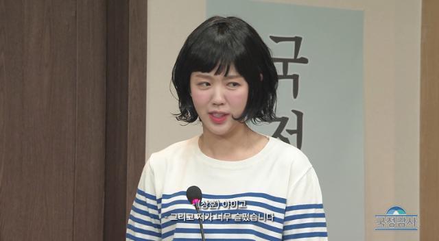 Actor Ji Yea-un mimics NewJeans member Hanni’s testimony in broken Korean during a National Assembly audit in an “SNL Korea” skit. Captured from Coupang Play