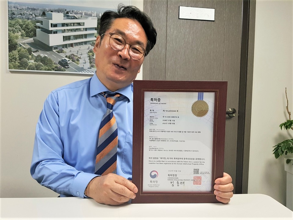 이상은 시더스그룹 회장이 ‘포인터 환원에 따른 블록체인 기반의 가상화폐 중개 및 유통 시스템’의 특허장을 들어보이고 있다.(사진=시더스그룹 제공)