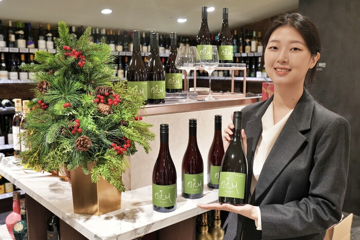 모델이 본점 와인 매장에서 제임스 서클링이 만든 와인을 들고 홍보하는 모습 (사진=롯데백화점)