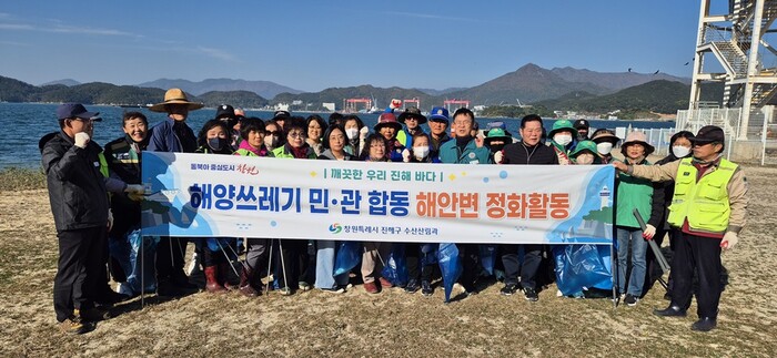 이승룡 진해구 대민안전관리관이 웅천동 자생단체 등과 소쿠리섬 정화활동 나서 사진촬영 모습.(사진=창원시) 