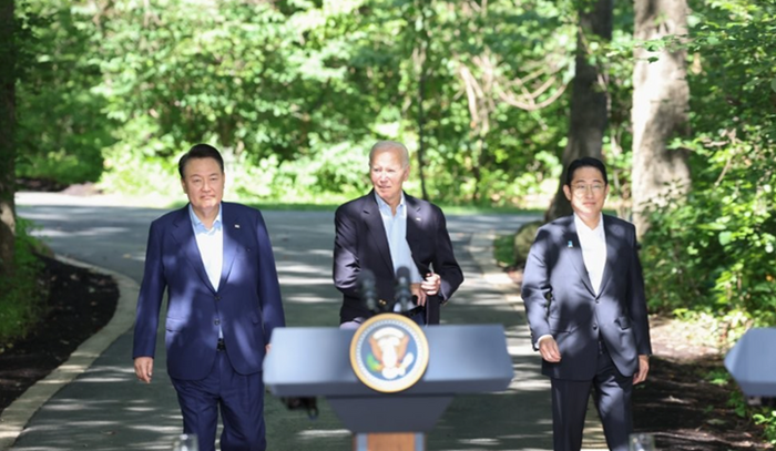 윤석열 대통령(왼쪽부터), 조 바이든 미국 대통령, 기시다 후미오 일본 총리가 지난해 8월 18일(현지시간) 워싱턴DC 인근 미국 대통령 별장인 캠프 데이비드에서 기자회견장에 걸어오고 있다. ⓒ연합뉴스
