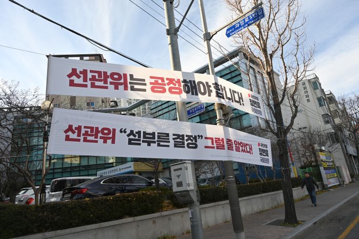 정연욱 국민의힘 의원이 공정한 관리자 역할을 잘 해달라고 촉구하기 위해 23일 오후 부산 수영구 선거관리위원회 앞에 내건 
