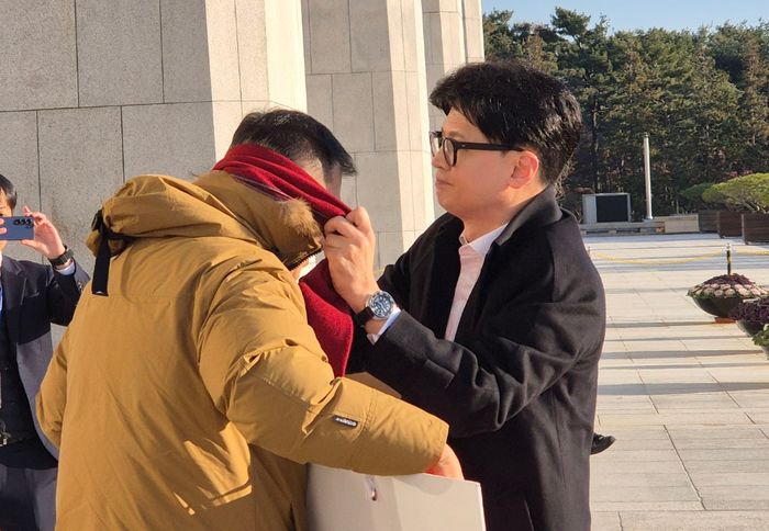 한동훈 국민의힘 전 대표가 지난 14일 국회본청 앞에서 김상욱 의원에게 목도리를 둘러주고 있다. ⓒ뉴시스