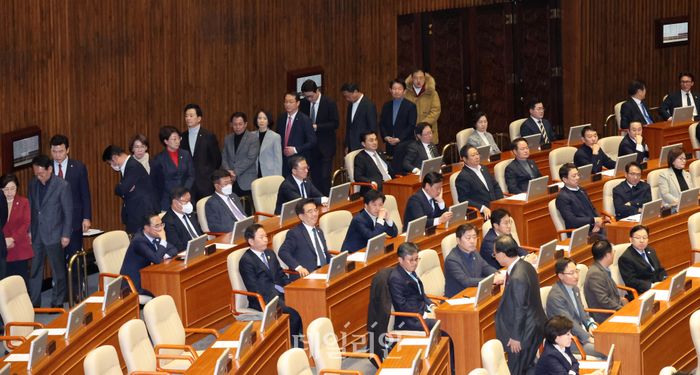 국민의힘 의원들이 지난 14일 오후 서울 여의도 국회에서 열린 제419회국회(임시회) 제4차 본회의에서 윤석열 대통령 탄핵소추안 투표를 위해 줄을 서 기다리는 동안 더불어민주당 의원들이 자리에 앉아 있다.ⓒ뉴시스
