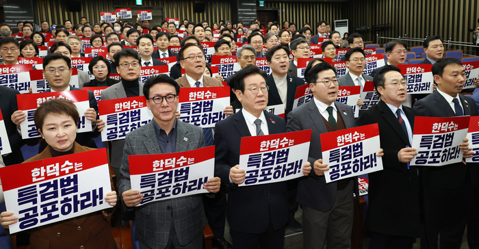 더불어민주당 이재명 대표(앞줄 왼쪽 세번째)와 박찬대 원내대표 등 의원들이 24일 오후 국회에서 열린 의원총회에 앞서 '한덕수는 특검법 공포하라!'라고 적힌 손팻말을 들고 구호를 외치고 있다. 연합뉴스