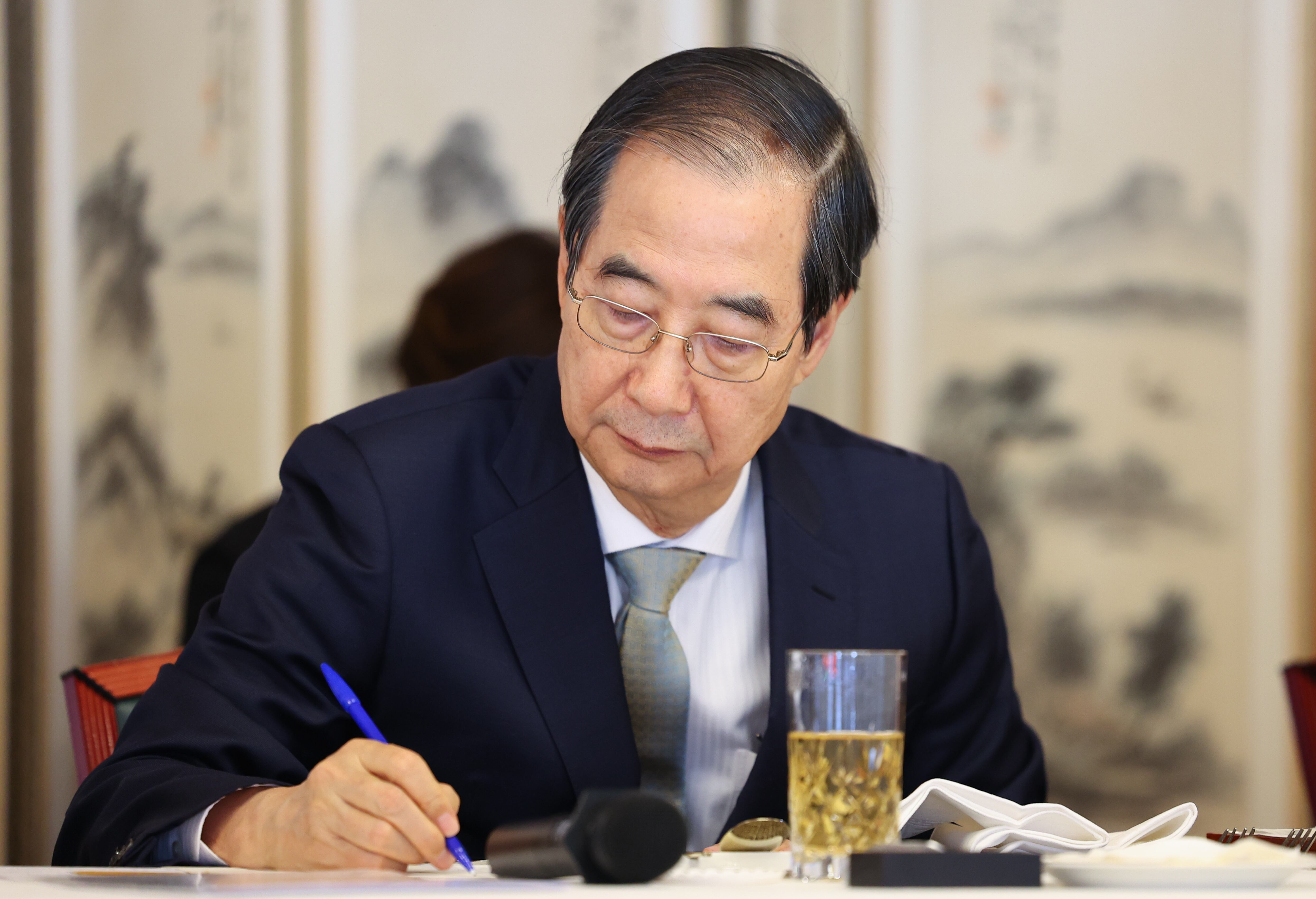 한덕수 대통령 권한대행 국무총리가 24일 서울 삼청동 총리 공관에서 열린 '서울재팬클럽(SJC) 오찬 간담회'에서 이구치 카즈히로 서울재팬클럽(SJC) 이사장의 인사말을 들으며 메모를 하고 있다. /연합뉴스