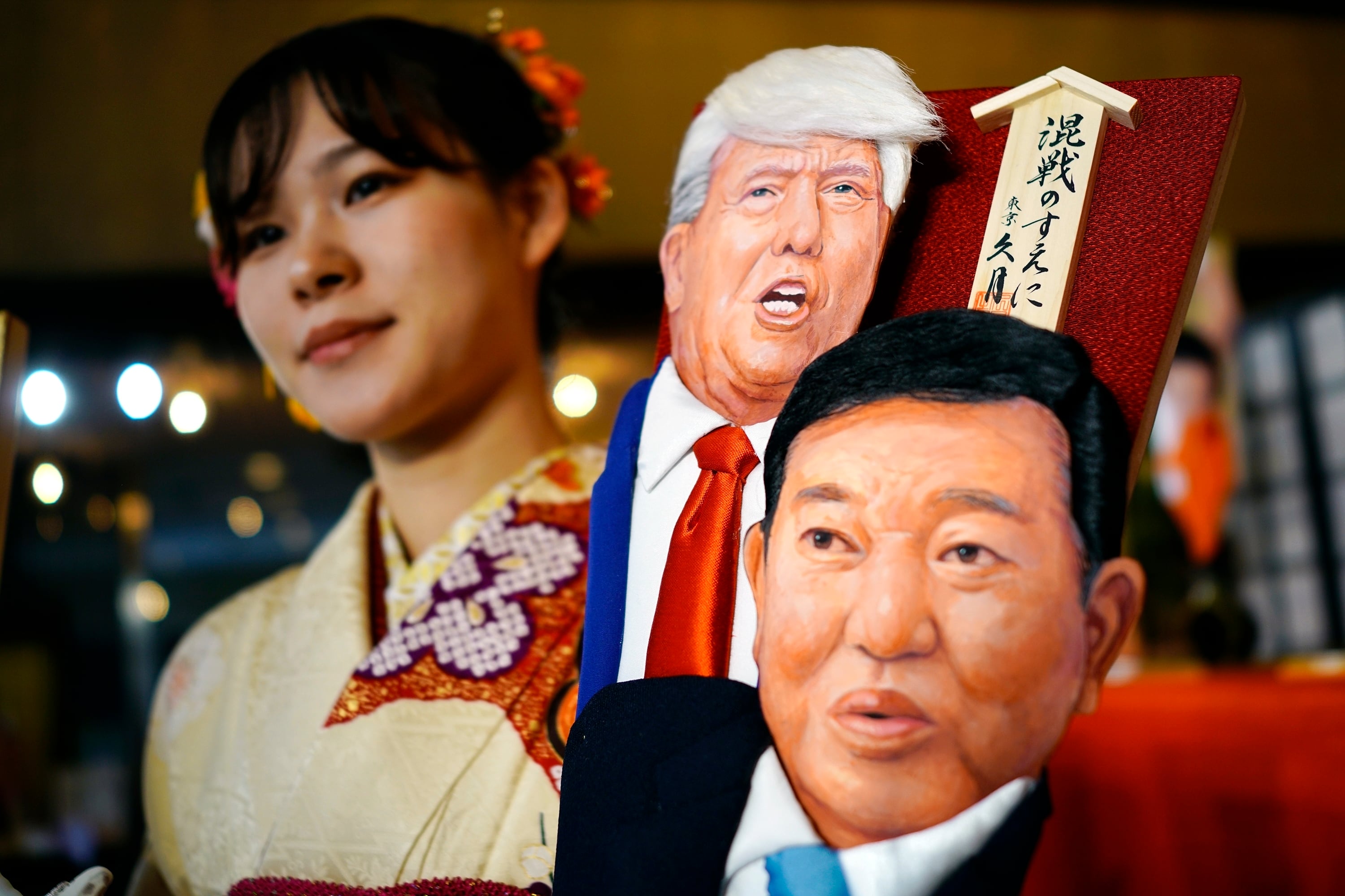 일본 전통 인형 회사인 큐게츠 직원이 도널드 트럼프 미국 대통령 당선인과 이시바 시게루 일본 총리가 그려진 상품을 들고 있다. / AP 연합뉴스 