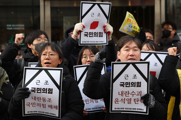  민주노총 및 언론노조 조합원들이 13일 오전 서울 여의도 국민의힘 당사 앞에서 윤석열 대통령 탄핵 표결 동참을 촉구하는 탄핵버스 출정식을 열고 있다(연합뉴스)