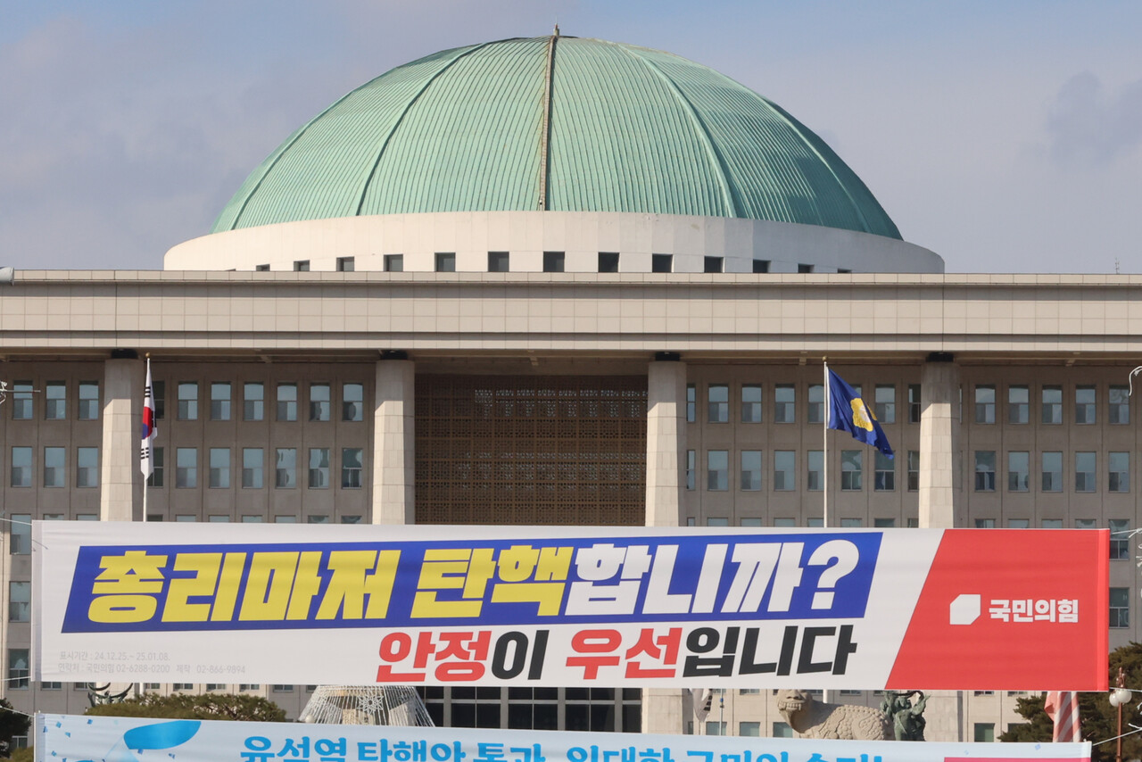 더불어민주당이 한덕수 대통령 권한대행 국무총리에 대한 탄핵소추안을 만장일치 당론으로 채택한 가운데 25일 서울 여의도 국회의사당 정문에 