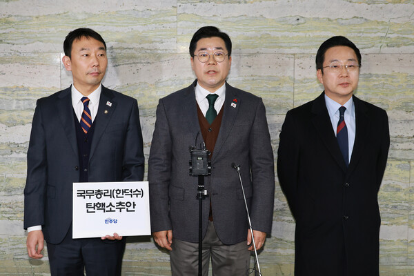더불어민주당 김용민 원내정책수석부대표(왼쪽부터)와 박찬대 원내대표, 박성준 원내수석부대표가 24일 오후 국회 의안과 앞에서 '국무총리 한덕수 탄핵소추안' 제출 보류 이유를 밝히고 있다. [연합뉴스]