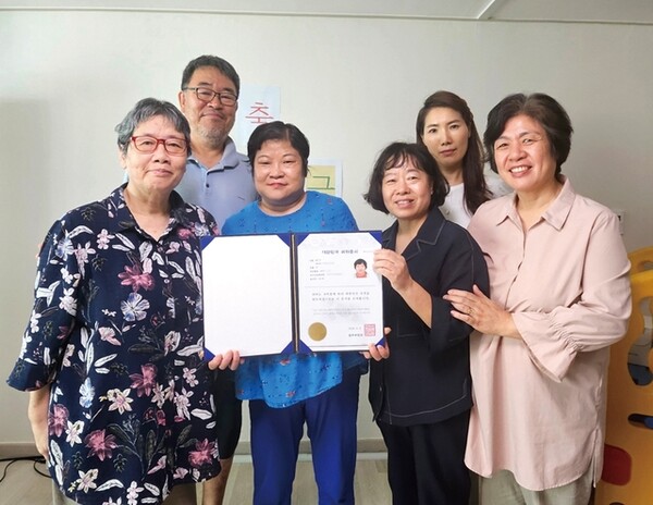 ▲최근 법무부로부터 귀화증서를 받은 중증장애 외국인 왕모(52)씨와 보호시설, 시민단체 관계자들이 단체 사진을 찍은 모습./인천일보DB