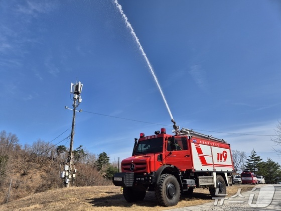 During a large-scale wildfire preparedness and response drill organized by the Gangwon Provincial Fire Department at the former campus of Hanzhong University in Donghae City, a high-performance wildfire suppression vehicle (Mercedes Unimog) was observed spraying water. This drill was part of the region\'s efforts to prepare for potential large-scale wildfires along the eastern coast of South Korea, testing both ground and aerial firefighting capabilities. / News1